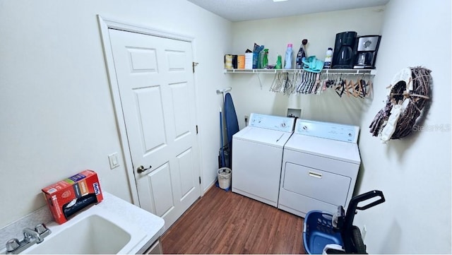 clothes washing area featuring a sink, independent washer and dryer, dark wood-style flooring, and laundry area