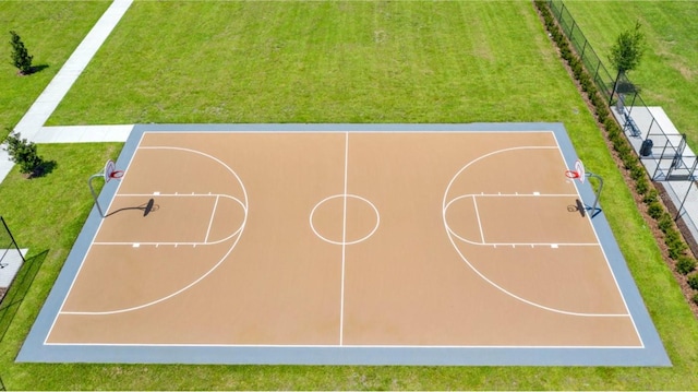 view of sport court with community basketball court, fence, and a lawn