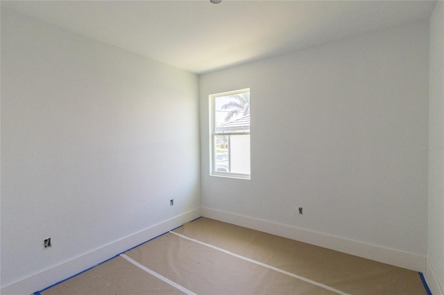 unfurnished room with baseboards