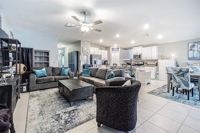 living room featuring light tile patterned floors, visible vents, a ceiling fan, lofted ceiling, and recessed lighting