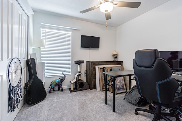 carpeted home office featuring a ceiling fan and baseboards