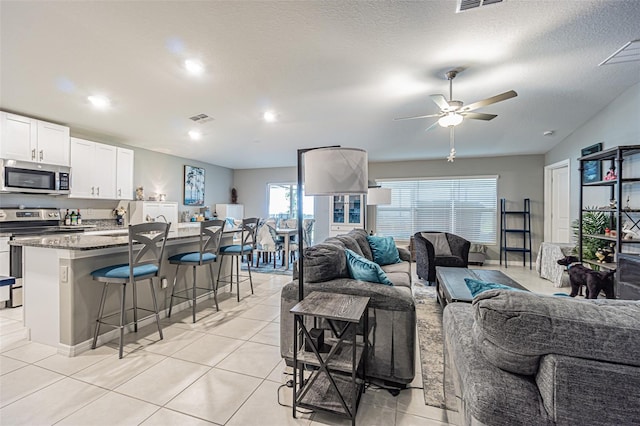 6494 Beverly Hills Dr, Zephyrhills, FL 33541 - living room featuring visible vents, a ceiling fan, and light tile patterned floors