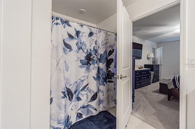 6494 Beverly Hills Dr, Zephyrhills, FL 33541 - bathroom featuring curtained shower, tile patterned flooring, and a textured ceiling