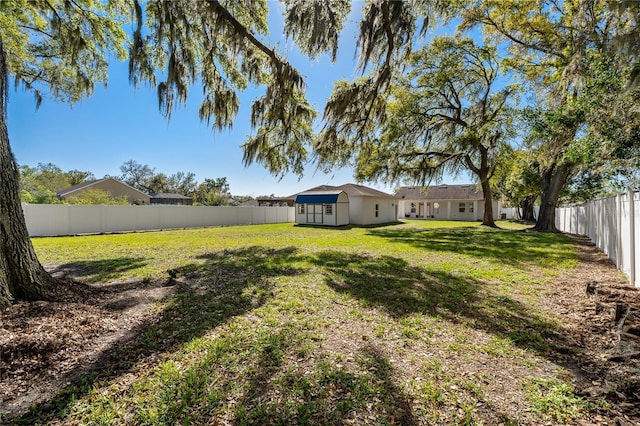 view of yard with an outdoor structure and a fenced backyard