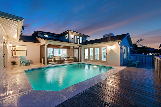 outdoor pool featuring a ceiling fan and a wooden deck