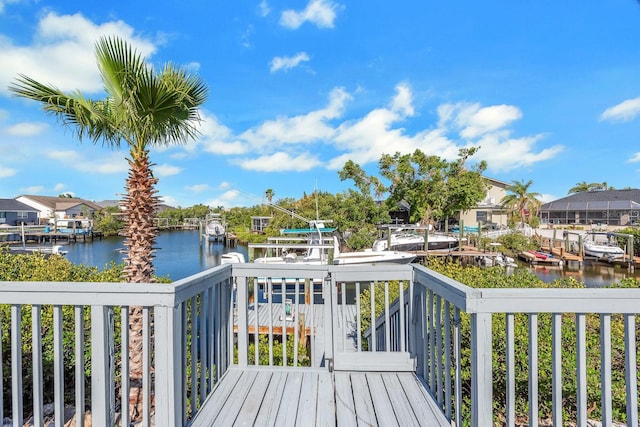 wooden terrace featuring a residential view, a water view, and a dock