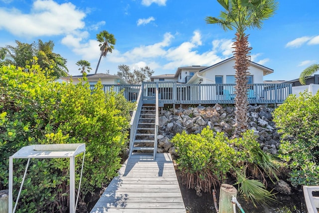 back of property with stairs, a wooden deck, and stucco siding