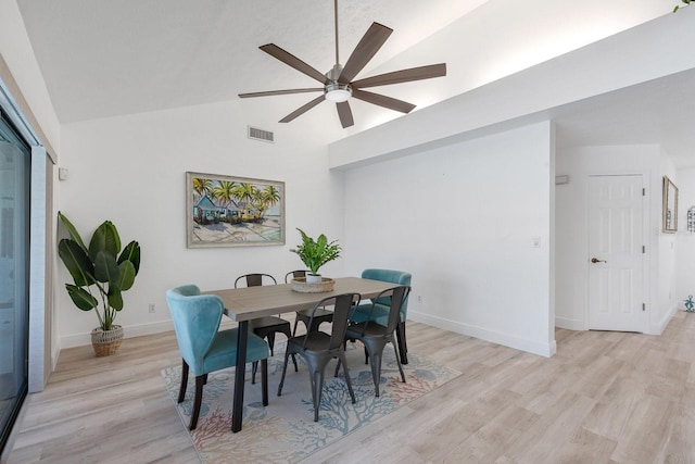 dining room featuring lofted ceiling, light wood-style flooring, a ceiling fan, visible vents, and baseboards