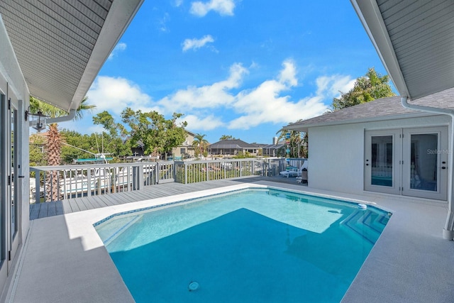 view of pool featuring french doors, a wooden deck, and a fenced in pool