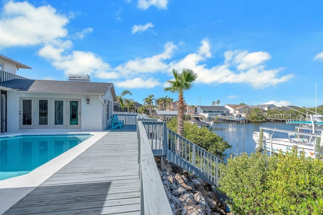 view of swimming pool with a water view, a residential view, and a fenced in pool