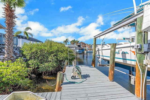 dock area with a water view and boat lift