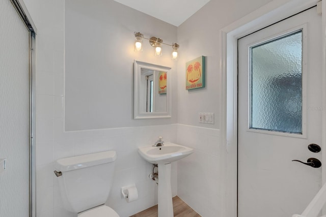 6606 Dolphin Cove Dr, Apollo Beach, FL 33572 - bathroom with tile walls, toilet, a wainscoted wall, and an enclosed shower