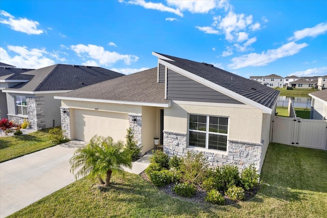 view of front of house with concrete driveway, stucco siding, stone siding, an attached garage, and a gate