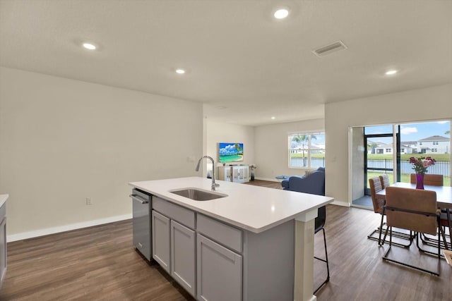 kitchen with visible vents, a sink, dishwasher, light countertops, and dark wood-style flooring