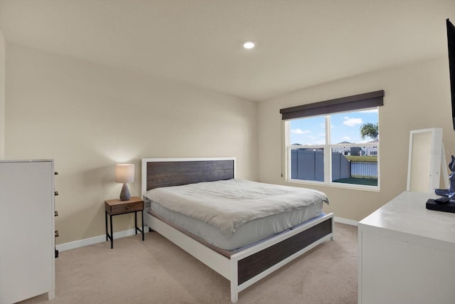 bedroom featuring baseboards and light carpet