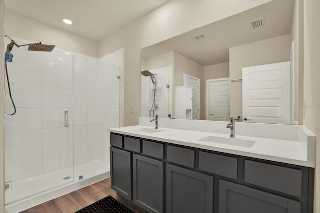 bathroom with a stall shower, visible vents, and a sink