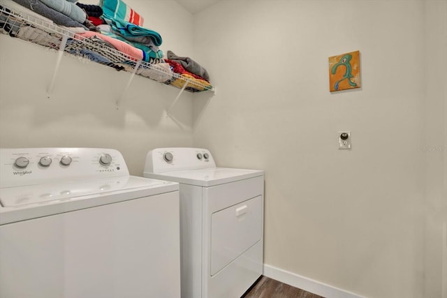 laundry area featuring laundry area, baseboards, dark wood-type flooring, and washing machine and clothes dryer