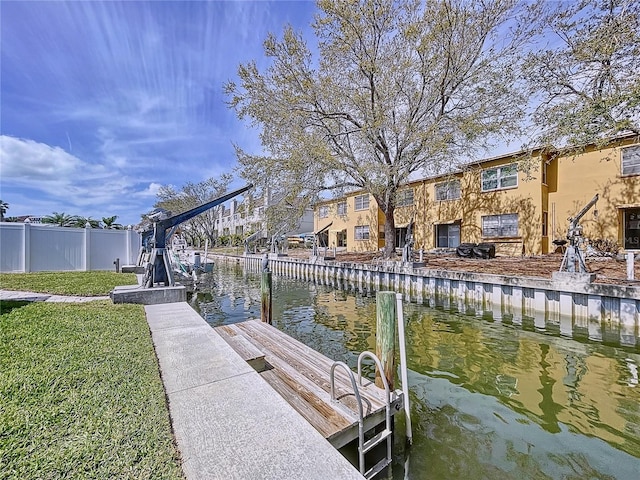 dock area with a yard, a water view, and fence