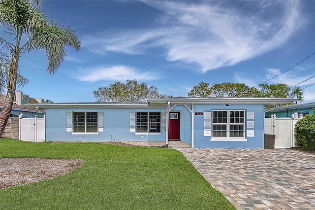 single story home with a front lawn, central AC unit, fence, and stucco siding