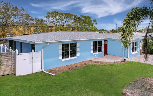 view of front of house with a front yard, a gate, and stucco siding