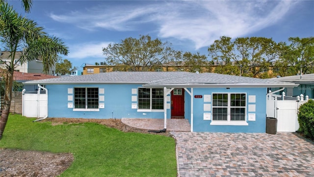 single story home with a gate, fence, a front lawn, and stucco siding