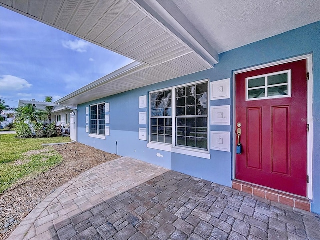 doorway to property featuring a patio and stucco siding