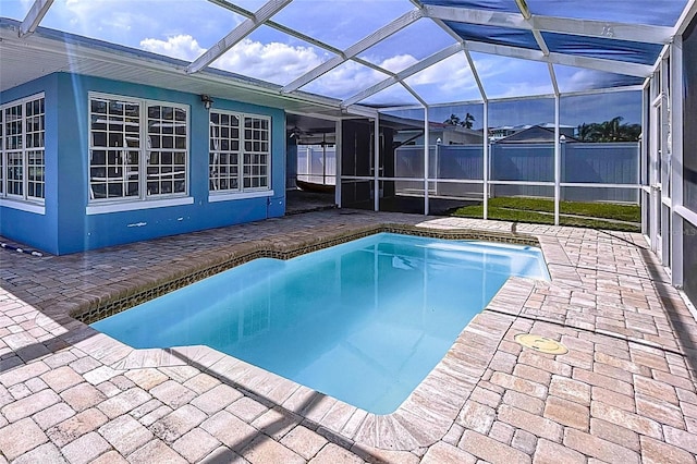 pool with a lanai, a patio, and fence