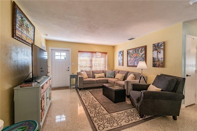 living room featuring light speckled floor and visible vents