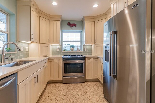 kitchen featuring recessed lighting, a sink, light countertops, appliances with stainless steel finishes, and decorative backsplash