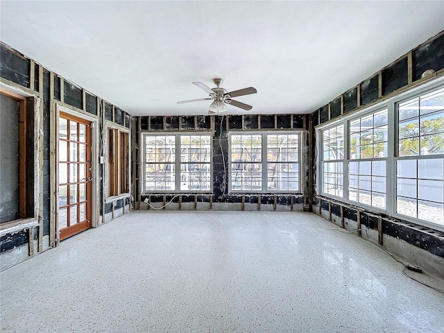 unfurnished sunroom with ceiling fan