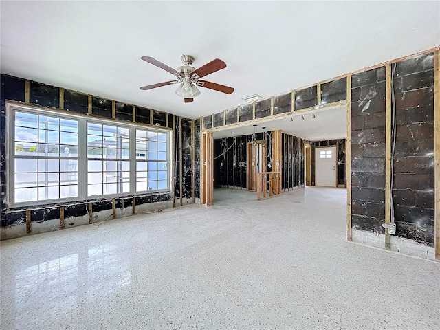 unfurnished room featuring a ceiling fan, visible vents, and speckled floor