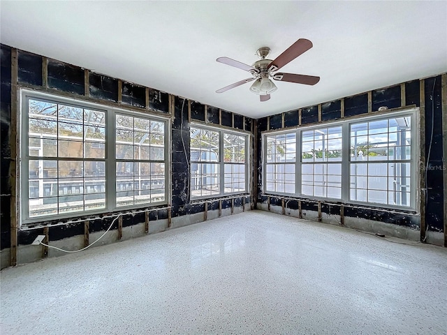 unfurnished sunroom with ceiling fan