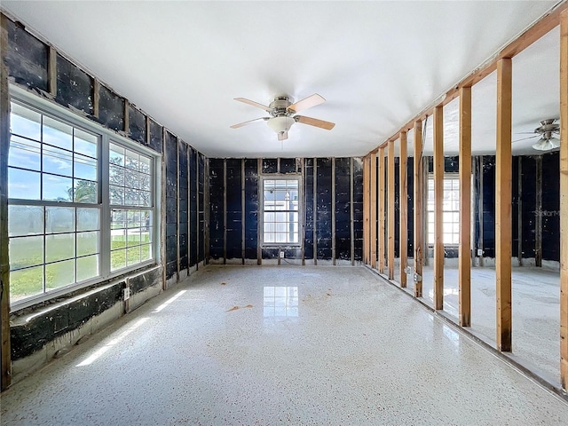 interior space with speckled floor and a ceiling fan