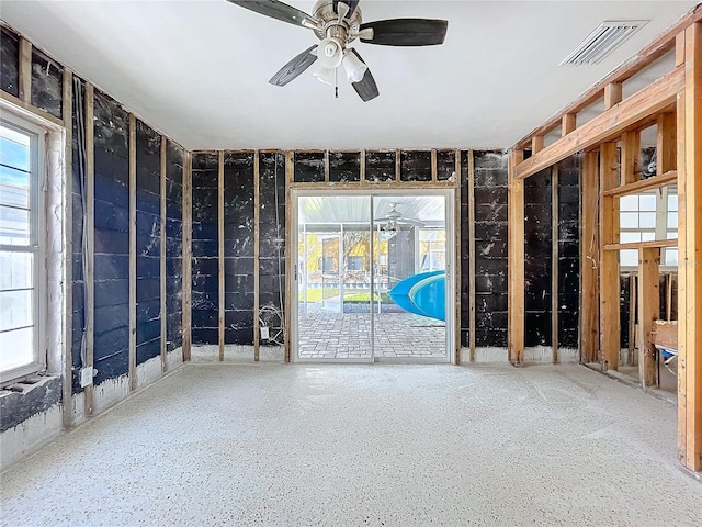 empty room with a ceiling fan, a healthy amount of sunlight, and visible vents