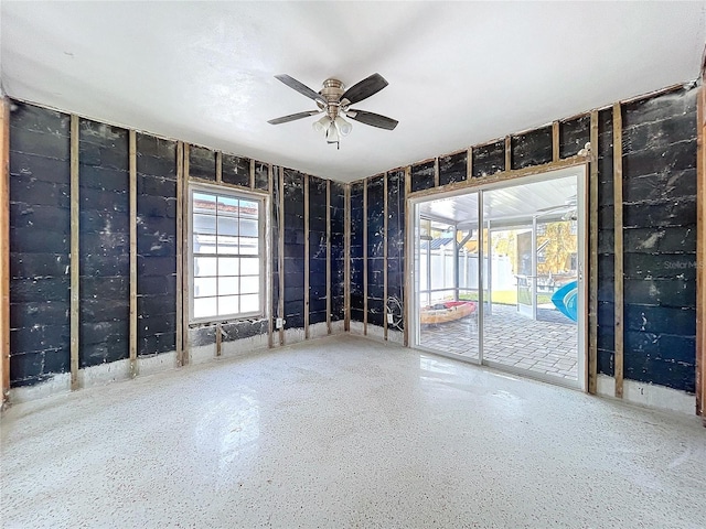 empty room with a ceiling fan and speckled floor