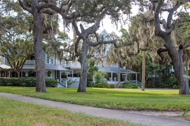 view of front of house with stairs, a porch, and a front yard