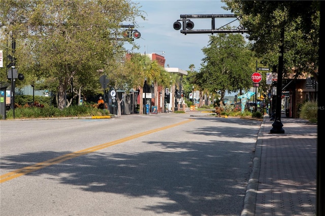 view of road with curbs, traffic signs, and sidewalks