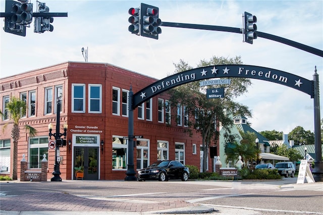 view of road featuring curbs, traffic lights, sidewalks, and street lighting