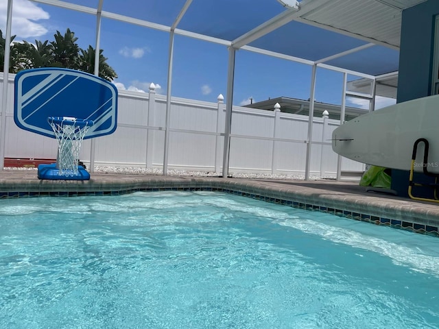 view of pool featuring a fenced in pool and glass enclosure