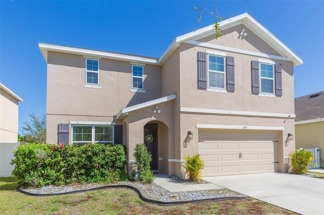 traditional home with an attached garage, driveway, and stucco siding