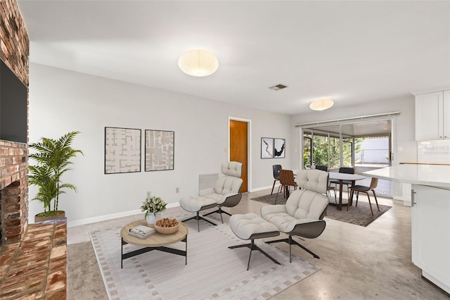 living room featuring visible vents, a fireplace, concrete floors, and baseboards