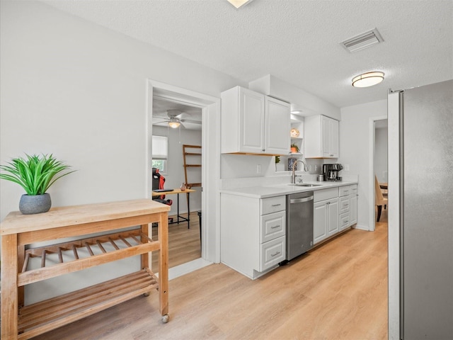 kitchen featuring a sink, visible vents, light wood-style floors, white cabinets, and appliances with stainless steel finishes