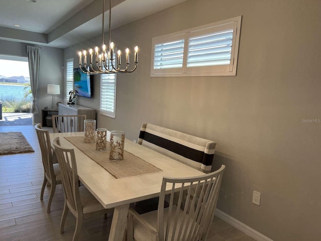 dining room featuring a notable chandelier, baseboards, and wood finished floors