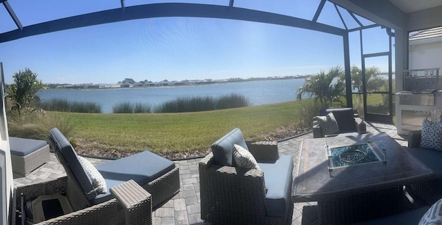 view of patio / terrace featuring a lanai and a water view