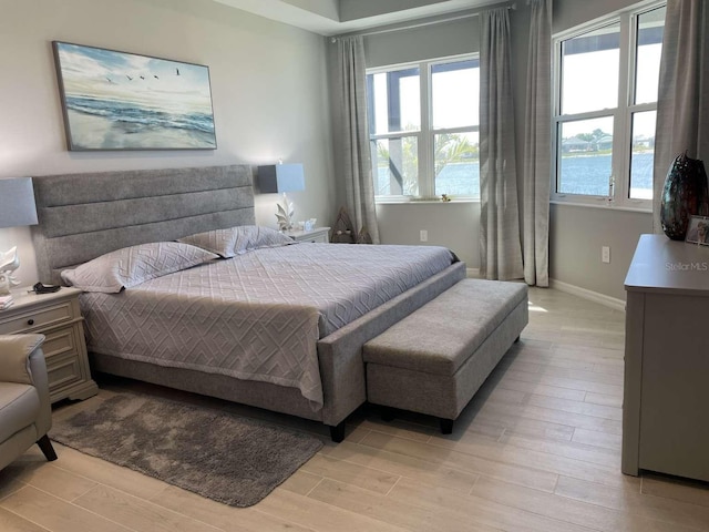 bedroom featuring multiple windows and light wood finished floors