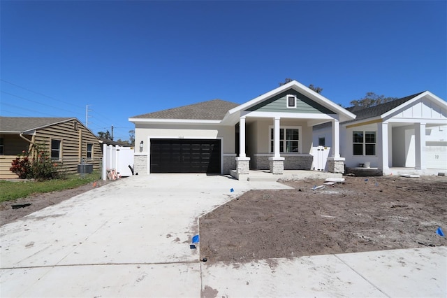 view of front of property with roof with shingles, covered porch, an attached garage, board and batten siding, and driveway