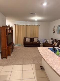 living area featuring light tile patterned floors and light carpet