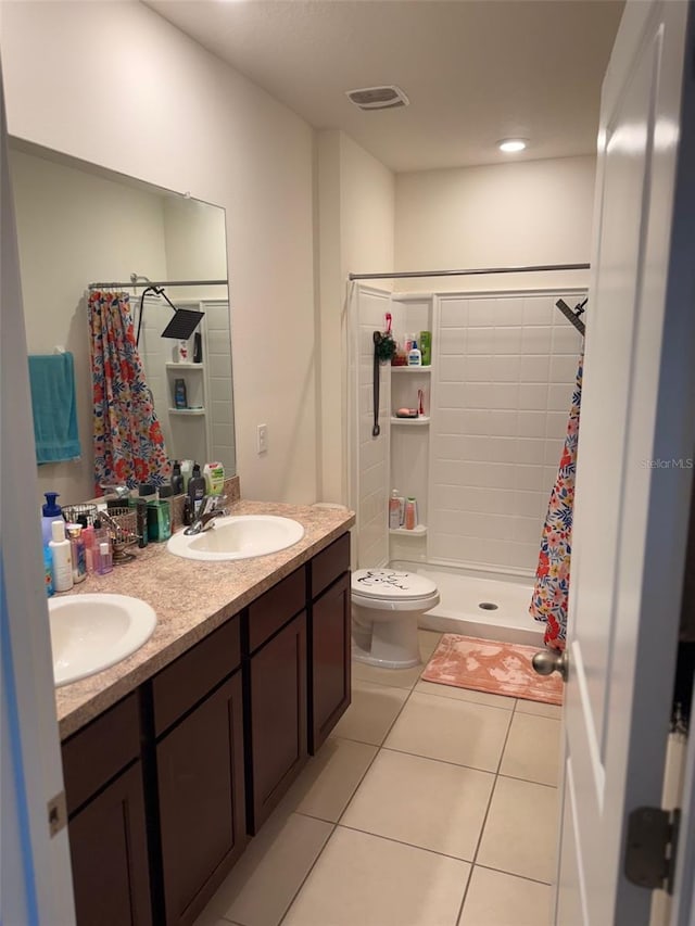 full bath with tile patterned floors, toilet, a stall shower, a sink, and double vanity