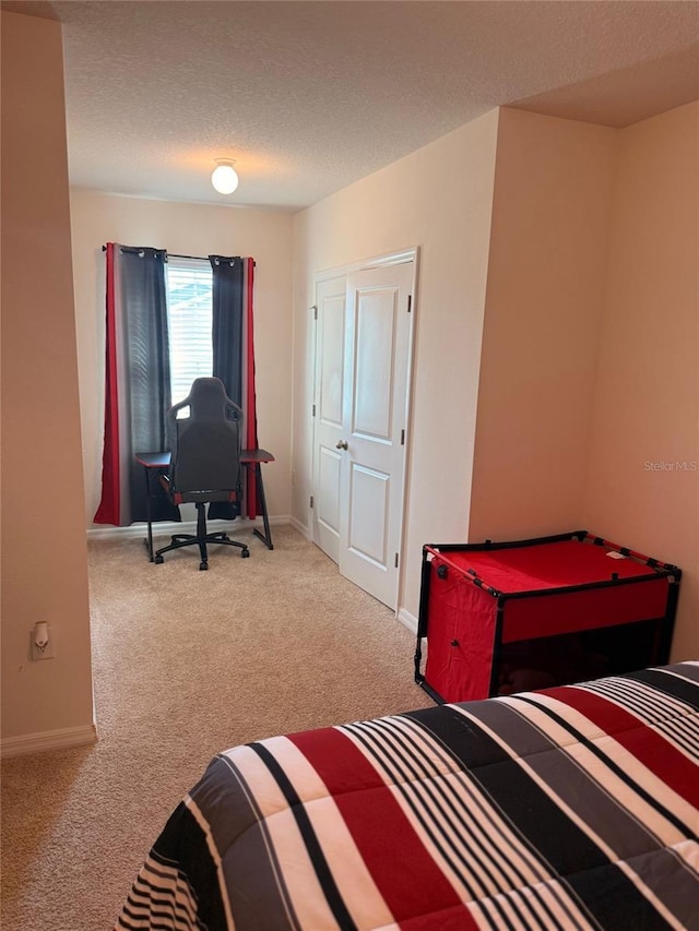 carpeted bedroom with baseboards and a textured ceiling