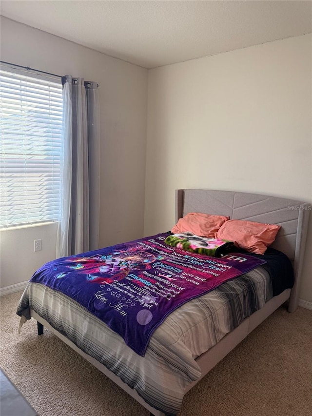 carpeted bedroom featuring baseboards